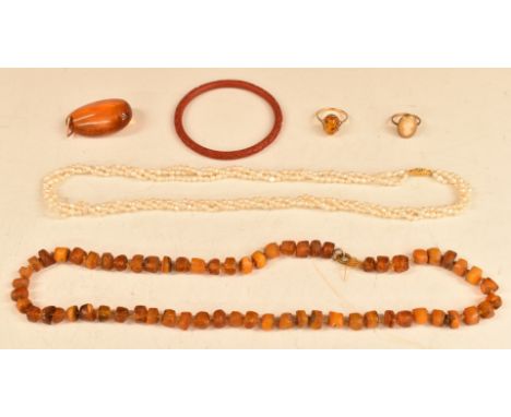 A 9ct gold ring set with a pressed amber cabochon, amber necklace, three strand pearl necklace, Chinese cinnabar lacquer bang