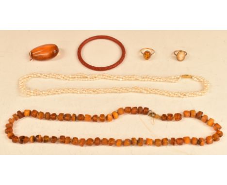 A 9ct gold ring set with a pressed amber cabochon, amber necklace, three strand pearl necklace, Chinese cinnabar lacquer bang