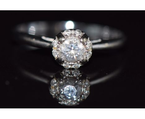 An 18ct white gold ring set with a diamond of approximately 0.2ct surrounded by further diamonds, 2g, size K