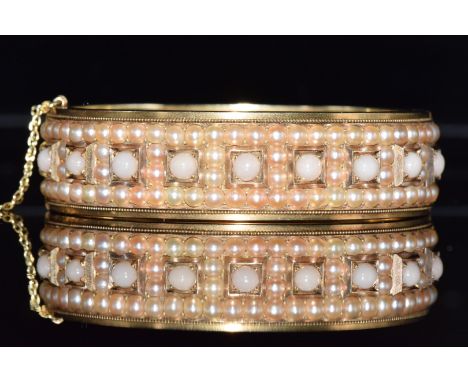 French gold Victorian bangle set with split pearls and coral cabochons, 5.5 x 4.6cm, 34.6g