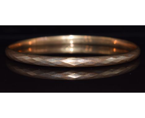 A 9ct gold flapper bangle with faceted decoration, Birmingham 1925, 7.4g, 7.6cm