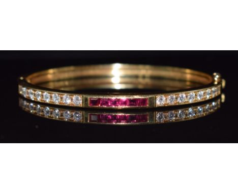 An 18k gold bangle set with round cut diamonds and square cut rubies, 21.1g, 4.8 x 5.8cm