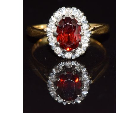 An 18ct gold ring with a garnet and diamonds, 4.1g, size K