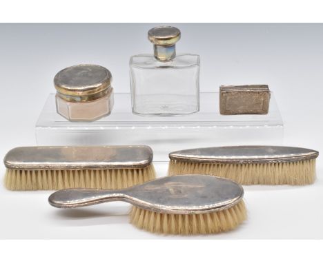 Silver mounted dressing table items comprising three brushes and two silver lidded glass items, all marked 930, together with