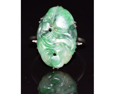 A white gold ring set with a carved jade panel, 4g, size O