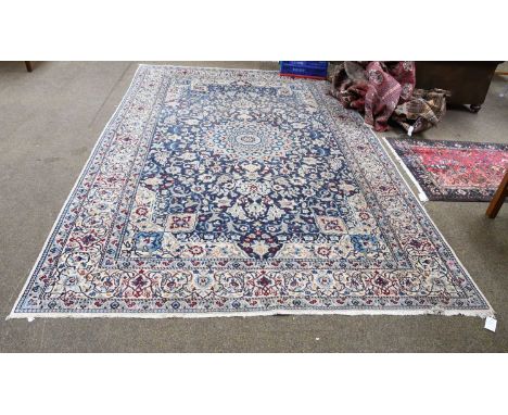 Nain Carpet, the indigo field of vines around a flowerhead medallion enclosed by ivory borders and meandering vine guard stri