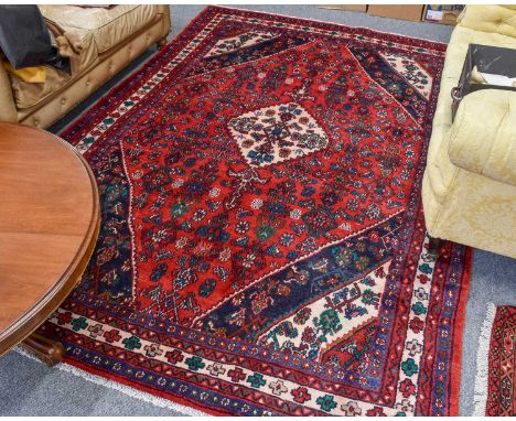 Hamadan Carpet, the blood red Herati field centred by a stepped ivory medallion, framed by spandrels and multiple narrow bord