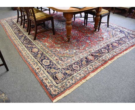 Mashad Carpet, the blood red field of scrolling vines centred by an indigo and ivory medallion, framed by spandrels and indig