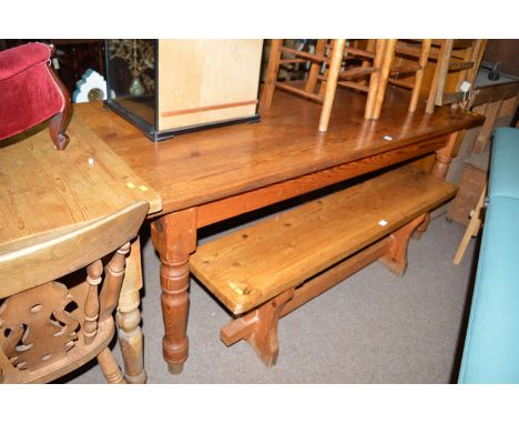 A rectangular pitch pine kitchen table with turned legs; and a pair of bench seats.