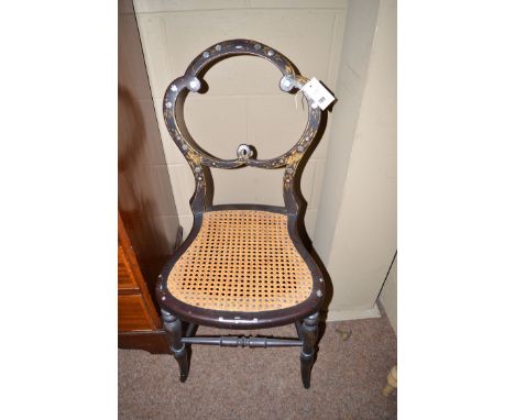 Two black lacquered gilt and mother-of-pearl inlaid occasional chairs, both with cane seats and turned legs joined by turned 