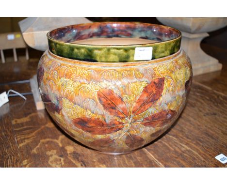 A large Doulton Stoneware jardiniere, decorated brown leaves on lighter leafy background.