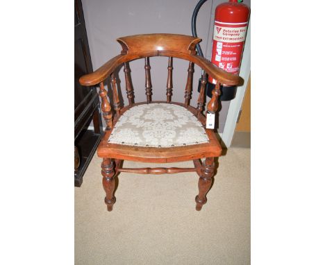 A 19th Century stained wood smoker's bow armchair, with shaped back and arms supported by turned spindles, the solid seat wit