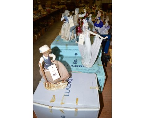 A Lladro group of a boy and girl dancing; together with two Lladro figurines, all boxed.