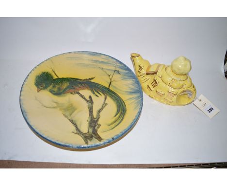A Lingard Webster teapot in the form of 'The Old Lady in the Shoe';  and a continental charger decorated a bird.  (2)