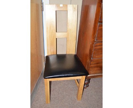 A set of six light stained wood modern design dining chairs with black leather seat cushions.