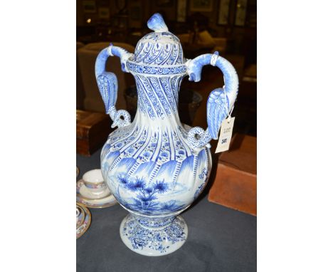 A large Dutch Delftware two handled blue and white vase and cover, the body of globular form painted with amorous couples wit