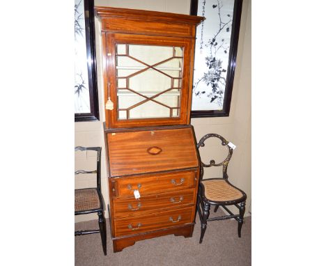 An Edwardian inlaid mahogany bureau bookcase, the flared cornice above an inlaid frieze, astragal glazed doors enclosing line