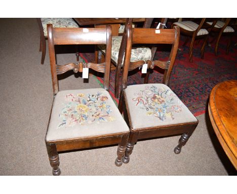A set of four mid 19th Century mahogany dining chairs, with plain cresting rails and reeded scrolling mid rails above tapestr