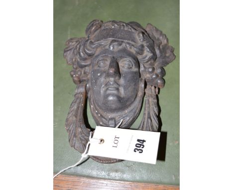 A cast metal door knocker in the form of a head.
