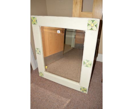A painted framed wall mirror, the square bevelled mirror panel within a painted frame set floral pattern tiles.