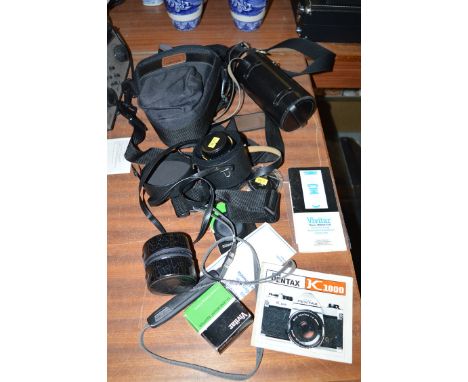 An Asahi Pentax K1000 35mm SLR camera; a selection of four lenses; instruction manuals; etc.