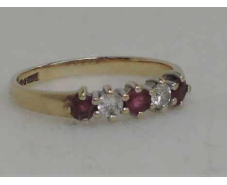 A ladies dress ring having three rubies interspersed by two diamonds in a claw setting on a 9ct gold loop