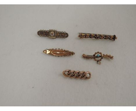 Five  yellow metal  bar brooches including  one stamped 9ct having twist decoration and central panel set with ruby and seed 