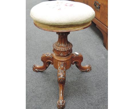 A Victorian mahogany frame piano stool having later tapestry swivel top on trefoil legs