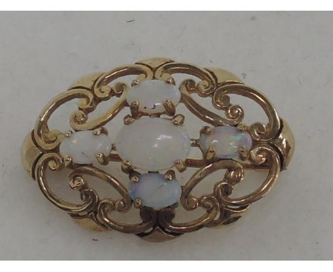 A yellow metal brooch of oval pierced form having opal decoration, no marks, tested as 9ct gold