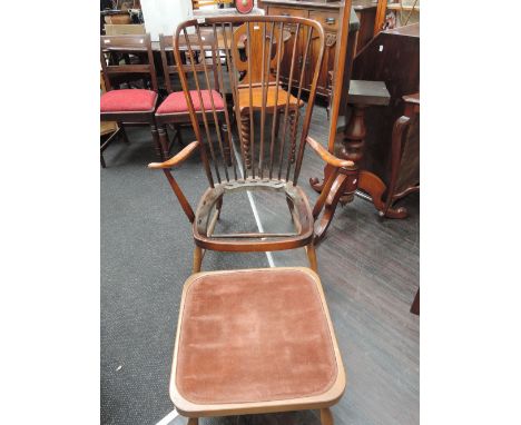 A 1960's design stained Ercol armchair having spindle back and similar footstool