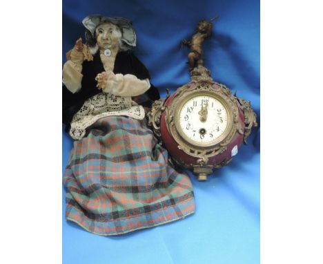 A part 19th century continental mantel clock having cast cherub decoration and a wax head doll modelled as Scottish lady