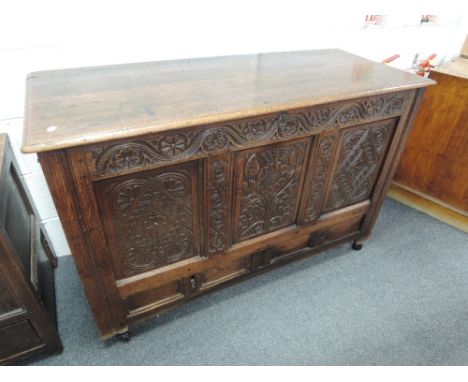 An 18th century oak mule chest having carved panel decorated with typical drawer base on stile frame