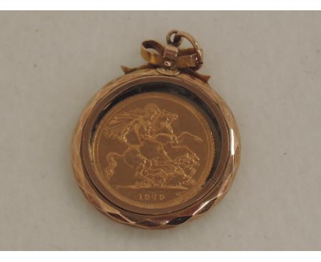 A gold sovereign dated 1979 in a glass locket with yellow metal surround stamped 9ct