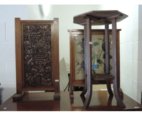 An early 20th century oak firescreen having carved bird and vine panel decoration, a similar oak table and an embroidered fir