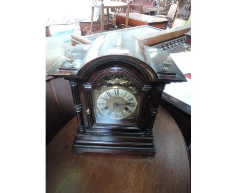 An early 20th century mahogany oak case period style mantel clock having brass finials and striking movement