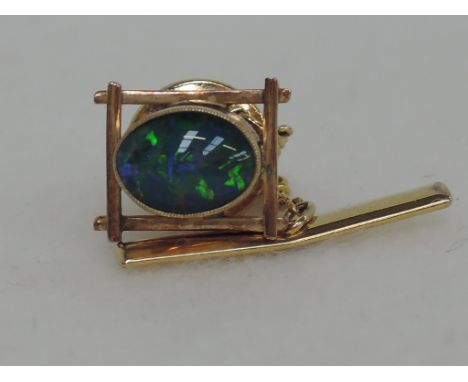 A yellow metal tie tac stamped 9ct set with a black opal doublet