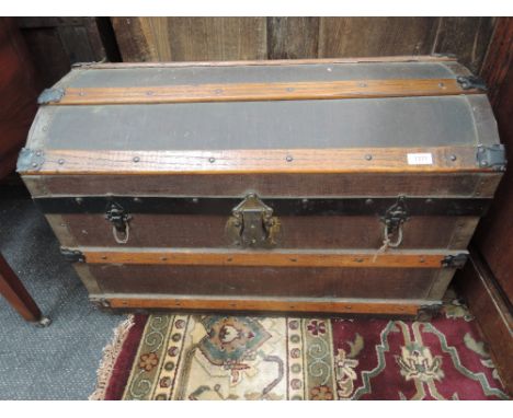 A vintage wood bound dome top cabin trunk