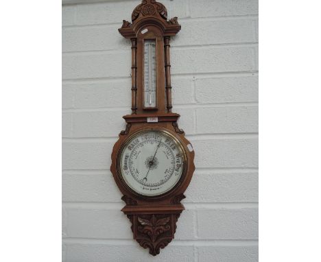 An early 20th century oak banjo aneroid barometer having crest with thermometer scale