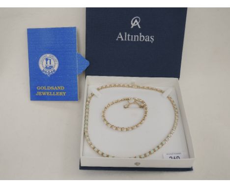 A four piece yellow metal, stamped 14K and synthetic opal set including earrings, ring, articulated necklace and bracelet, in