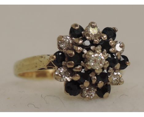 A ladies dress ring having a triple diamond and sapphire cluster on an 18ct gold loop