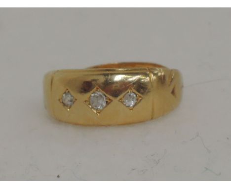 A ladies 22ct gold band ring set with 3 diamond chips 