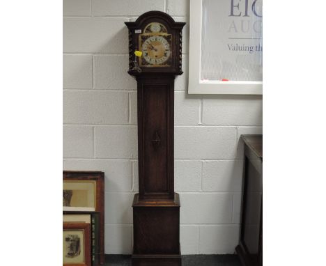 A mid 20th century oak granddaughter clock having arch and twist hood with chiming movement, on trunk and base