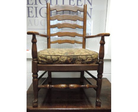 A late 20th century oak armchair in the 18th century style having ladder back, squab cushion seat and turned frame