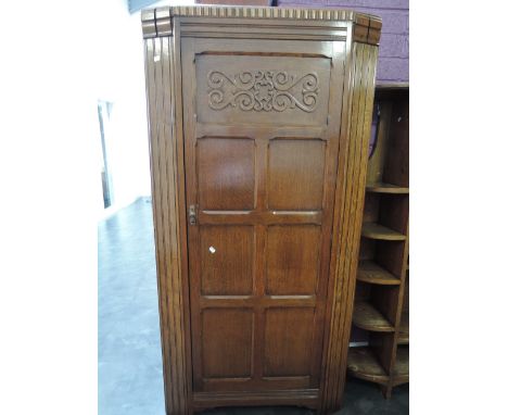 A mid 20th century oak hall wardrobe having applique and panel door