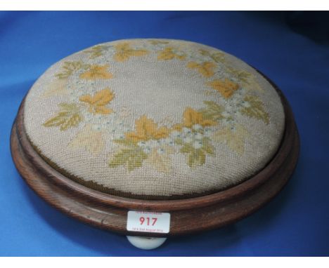 A 19th century circular oak footstool having beaded inset and tri ceramic feet