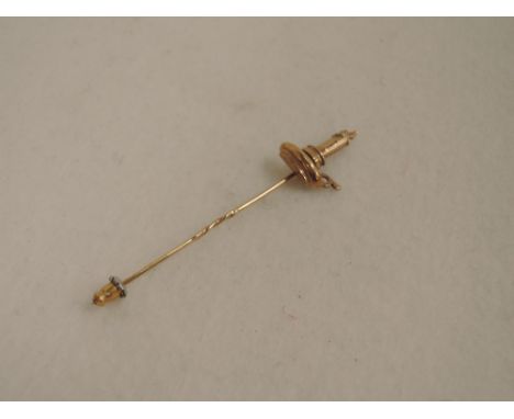 A 9ct gold stick pin modelled as a chamber stick with lit candle