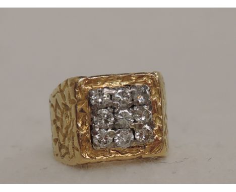 A yellow metal signet ring having a 9 stone diamond square decoration on an engraved moulded loop stamped 18ct,  approx 8.8g