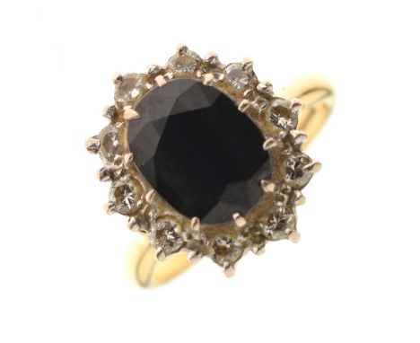 Sapphire and diamond 18ct gold cluster ring, the oval cut sapphire 8mm x 10mm approx, within a border of ten round brilliant 