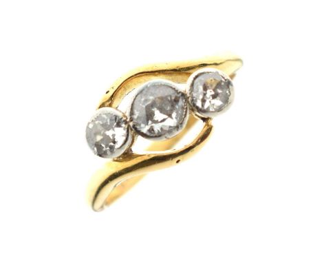 Three-stone diamond crossover ring, the graduated old cut diamonds millgrain set in white metal, the yellow metal shank indis