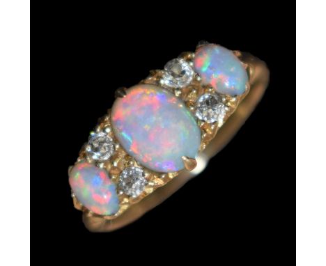 Edwardian opal and diamond 18ct gold boat cluster ring, the three graduated oval opal cabochons with pairs of old cut diamond
